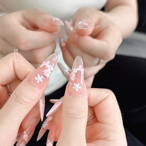 Detail of peach blossom stiletto nail art stickers with 3D embossed floral and rhinestone accents