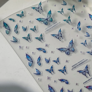Macro view of blue butterfly nail stickers with star motifs and PET texture details