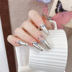 Detail of long coffin nails with blue butterfly patterns and silver metallic finish