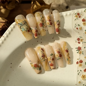 Detailed view of vintage French press-on nails with floral bunny art and pearls