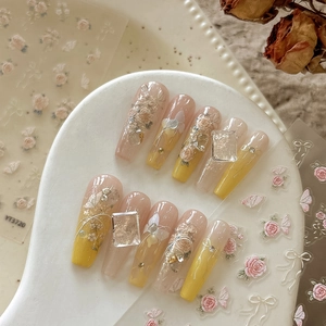 Detail of 3D embossed floral nail charms with gold foil on vintage french style nails