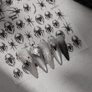 Detail of spider web nail stickers on dark gradient nails with heart rhinestone