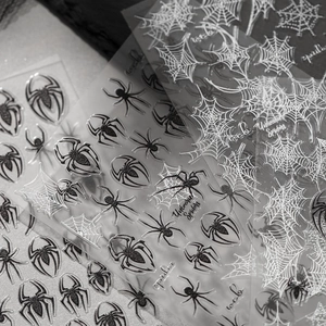 Detail of Halloween spider nail stickers with black glitter and silver web patterns