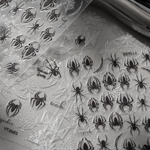 Macro detail of black and white spider and web nail art stickers for Halloween style