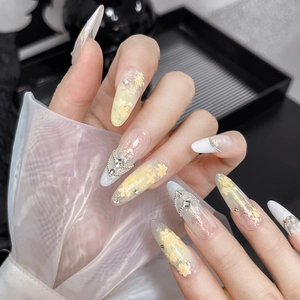 Ongles amandes longs à fleurs jaunes avec breloques 3D et chaîne de perles argentées