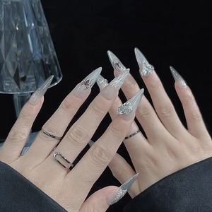 Gothic stiletto nails with spider web patterns and heart rhinestones for Halloween