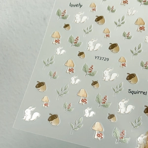 Detail of 3D embossed nail art stickers featuring squirrels, acorns, and forest mushrooms