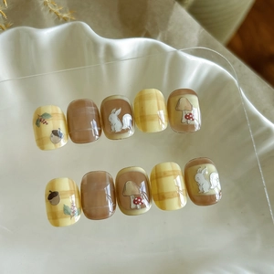 Detail of forest autumn press-on nails with squirrel, mushroom and plaid patterns