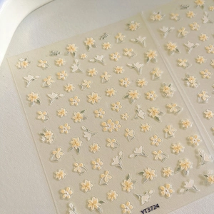 Détails macro d'autocollants gaufrés pour ongles avec fleurs jaunes et blanches