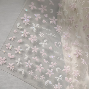 Macro detail of cherry blossom nail stickers with laser iridescent petals and text