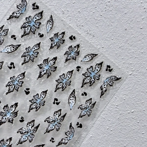 3D-Gelee weiße Blumen-Nagelaufkleber mit schwarzem Umriss und blauem Akzent auf Folie