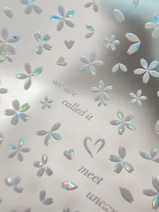 Macro shot of 3D embossed cherry blossom nail stickers with laser rainbow pearl effect