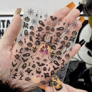 Macro detail of Halloween nail stickers featuring pumpkins, bats, and ghosts patterns