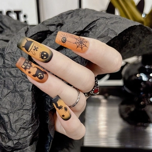 Macro shot of Halloween long coffin fake nails with pumpkin and spider web designs