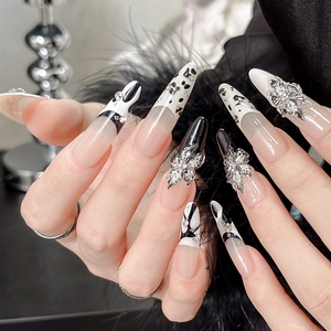 Detailansicht der 3D Silberblumen und schwarzen Kuhmuster auf langen Stiletto-Nagelaufklebern