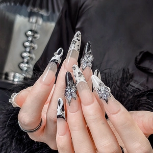 Detail von Gothic-Stiletto-Klebenägeln mit Schmetterling-Anhängern und Glitzer-Strass