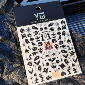 Detailed view of Halloween nail art stickers with black and orange pumpkin bat motifs
