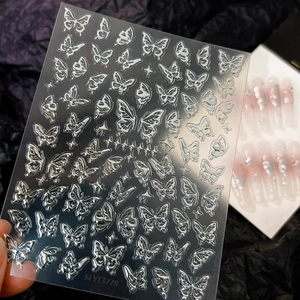 Vista macro dettagliata di adesivi per unghie a farfalla 3D argento con texture metallica