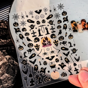Close-up of Halloween nail stickers with ghost, pumpkin and bat patterns in black and orange