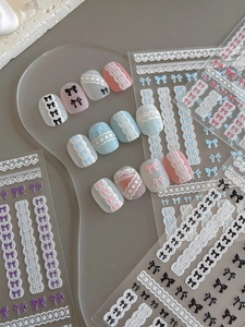 Gros plan de stickers ongles 5D en relief avec motifs de dentelle et de nœuds
