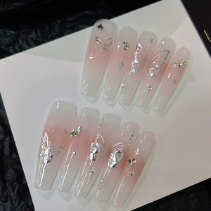 Dettaglio di unghie a bara sfumate rosa con farfalle d'argento e strass scintillanti