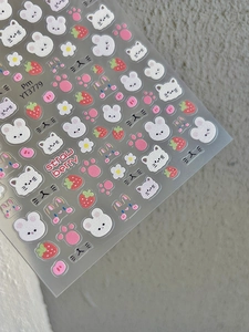 Detailed view of 3D embossed nail stickers featuring cute white cats and strawberry motifs