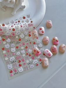 Close-up of cute strawberry and bunny nail stickers with pink cat claw patterns