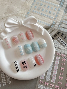 Détails de stickers nail art effet tricot avec nœuds et dentelle sur plateau céramique