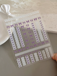 Détail des stickers ongles YT3762 avec nœud violet et motifs en relief de dentelle blanche