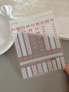 Gros plan des stickers nail art YT3761 avec nœuds roses et dentelle blanche en relief