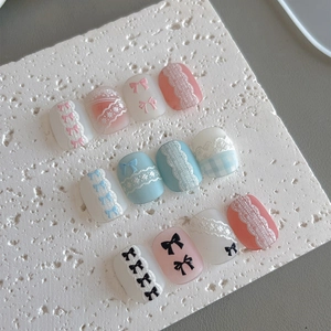 Faux ongles rose Morandi et bleu avec nœuds 3D et motifs de pull en relief doux