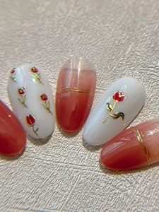 Gros plan d'autocollants pour ongles tulipes dorés avec motifs floraux rouges