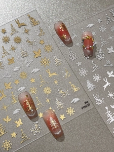 Detail view of silver Christmas nail art stickers with reindeer and snowflake patterns