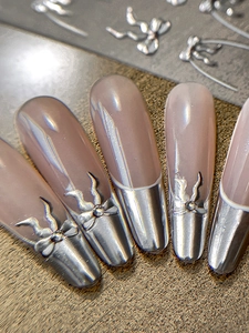Vista macro di unghie a mandorla con fiocco metallico argento e linee fluide 3D