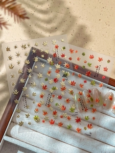 Macro shot of maple leaf nail art stickers with traditional Chinese calligraphy details