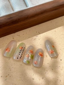 Detail of maple leaf nail stickers with Chinese calligraphy and golden foil accents