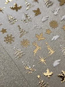 Detail of 3D embossed gold Christmas nail stickers with snowflakes and reindeer