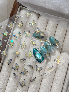 Detail of blue shimmering butterfly nail art stickers with gold outlines and samples