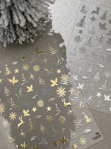 Macro shot of 5D embossed Christmas nail stickers with gold and silver snowflake motifs