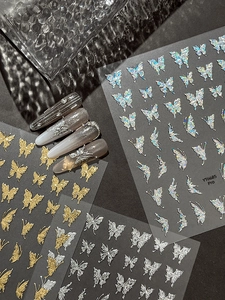 Macro shot of silver butterfly nail art stickers with 3D gradient manicured nails on black