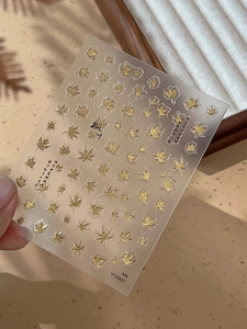 Detailed view of golden maple leaf nail stickers with poetic Chinese calligraphy motifs