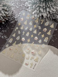 Detail of Christmas nail art stickers with gold foil trees and gingerbread house patterns