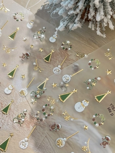 Détail de stickers à ongles 3D de Noël avec reliefs dorés et motifs festifs variés