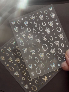 Detailed view of silver holographic butterfly nail art stickers with rainbow reflection