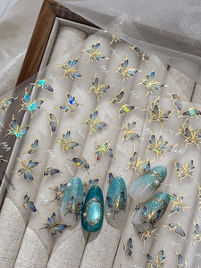 Detail of blue shell light butterfly nail stickers with gold foil and 3D pearl accents