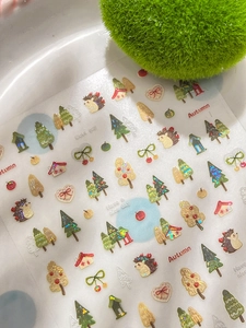 Dettaglio di adesivi per unghie 3D autunnali con ricci, pini e glitter brillanti