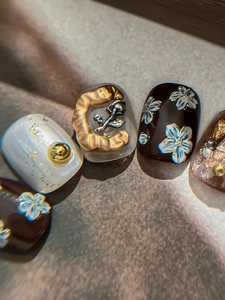 Macro detail of 3D embossed white flower nail stickers with gold rose charms and foil