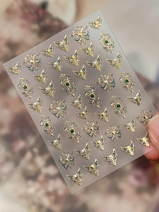 Close-up of vintage Chinese style embossed nail art stickers with gold and pearl details