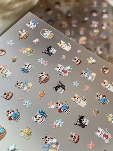 Detailed macro shot of 5D embossed nail art stickers with cute cartoon cat and flower patterns