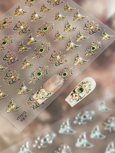 Macro shot of 5D embossed nail stickers featuring baroque patterns, emeralds, and pearls